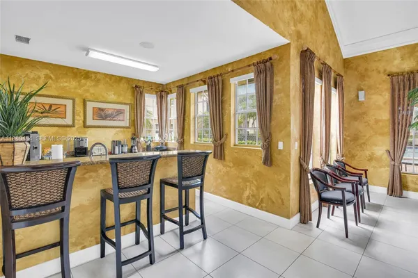 a dining room with furniture and large windows