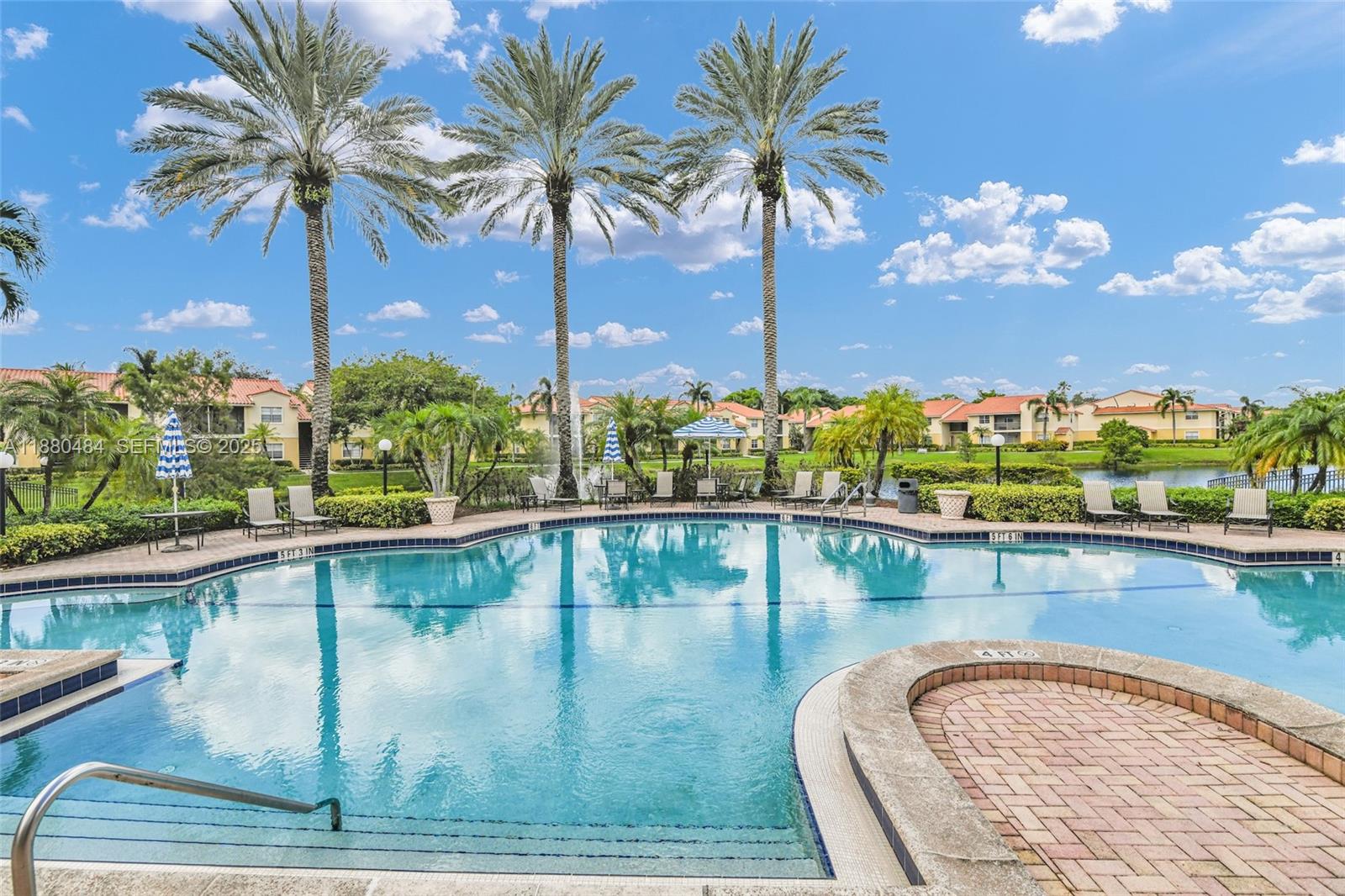 1255 Southwest 46th Avenue, Unit 1713 Pompano Beach, FL 33069 - Photo 27 of 37 a view of a swimming pool with a table and chairs