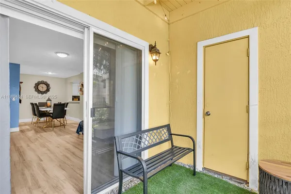 a view of a hallway with chairs and couches with wooden floor