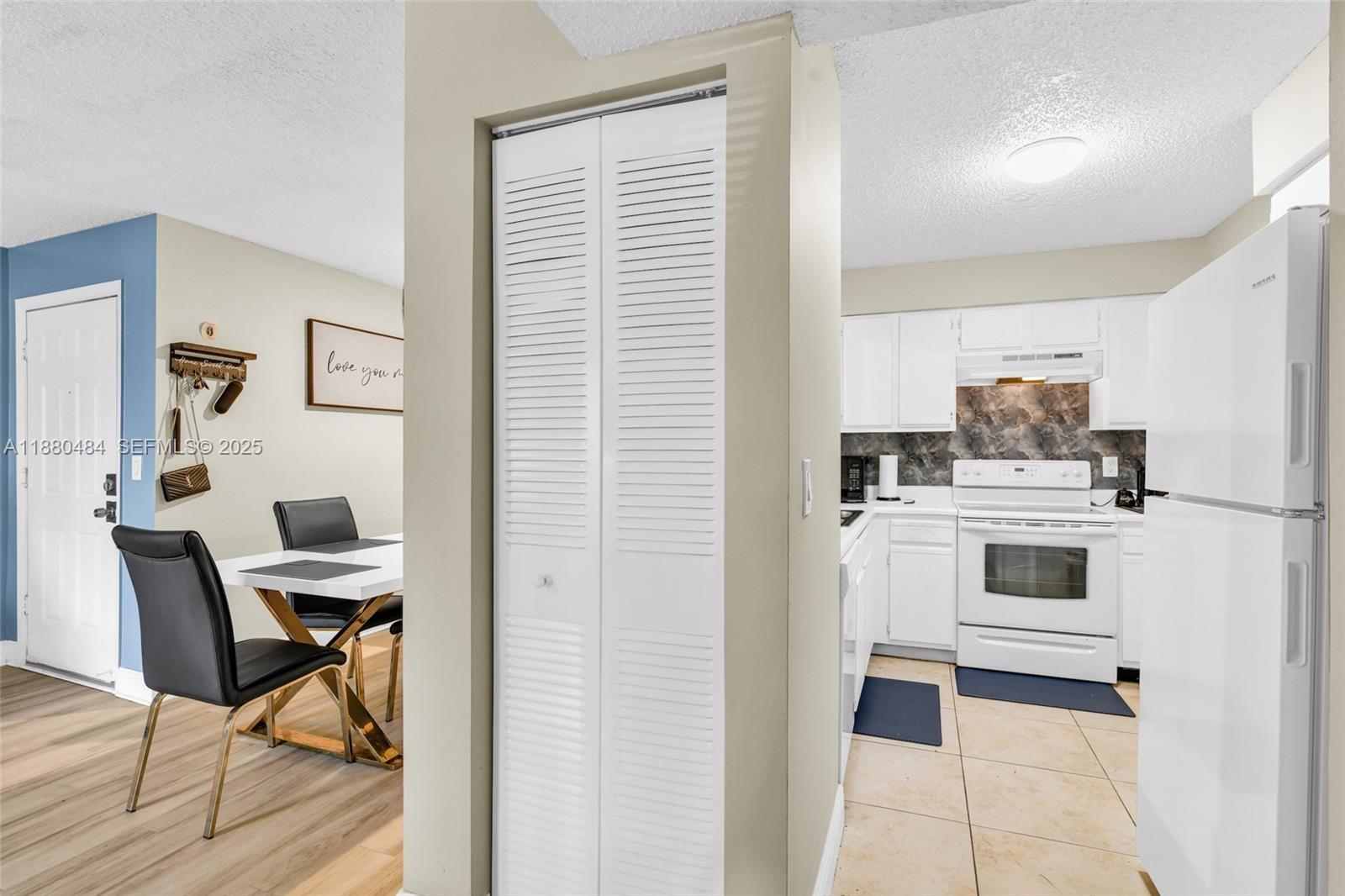 1255 Southwest 46th Avenue, Unit 1713 Pompano Beach, FL 33069 - Photo 10 of 37 a kitchen with a stove and white cabinets