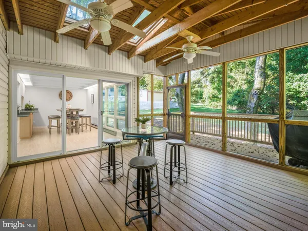 a view of a patio with a table chairs and wooden floor