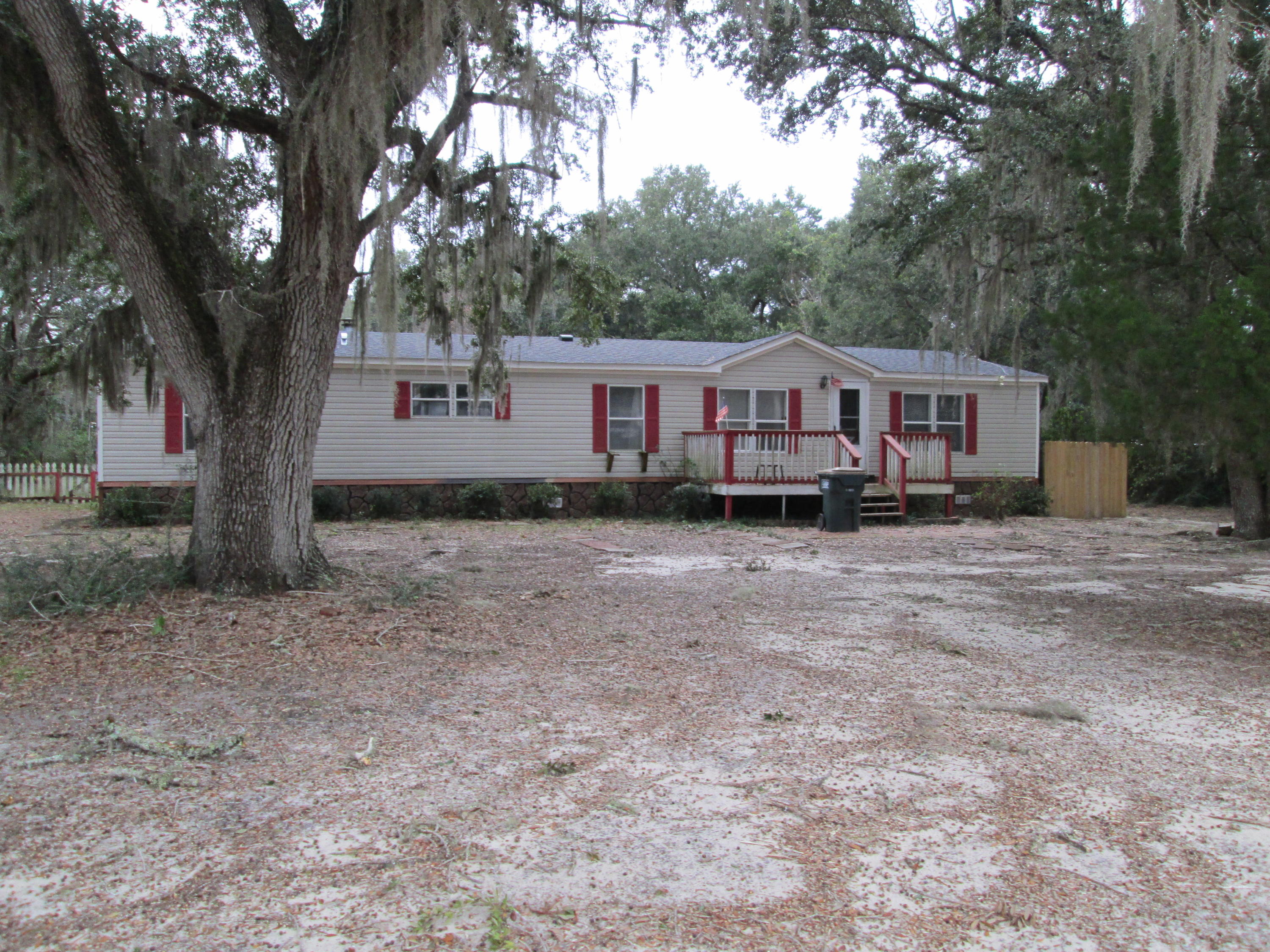 2765 Ola Broxson Road Navarre, FL 32566 - Photo 1 of 20 front view of a house with a tiny house and a large tree