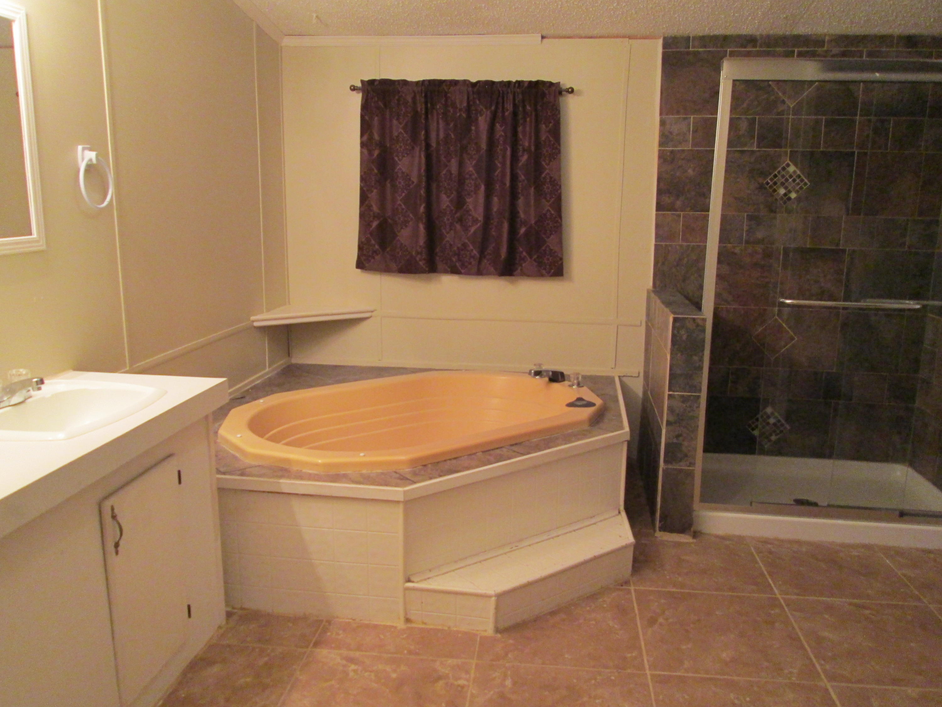 2765 Ola Broxson Road Navarre, FL 32566 - Photo 15 of 20 a bathroom with a tub a sink and a shower
