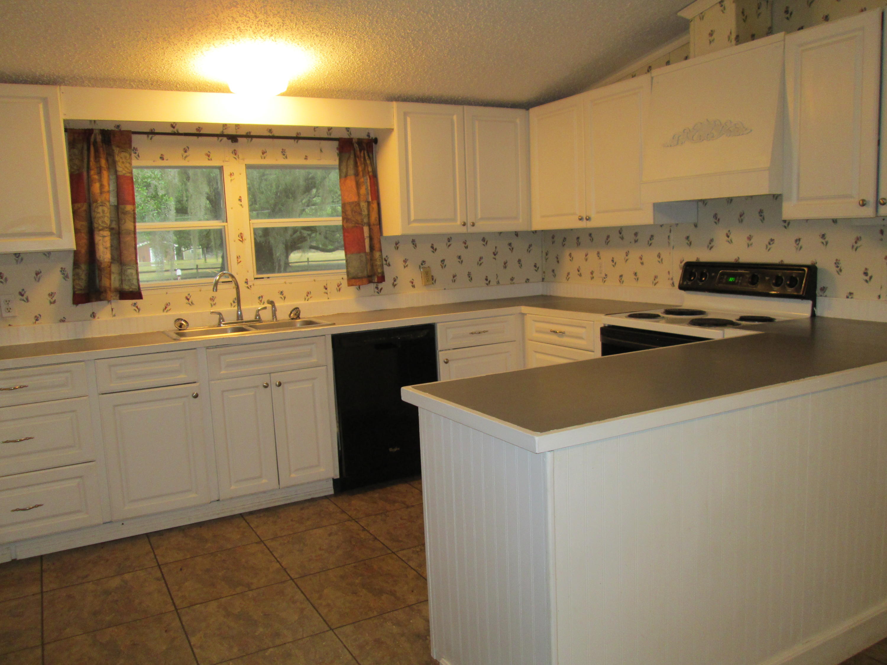 2765 Ola Broxson Road Navarre, FL 32566 - Photo 5 of 20 a kitchen with a sink stove and cabinets