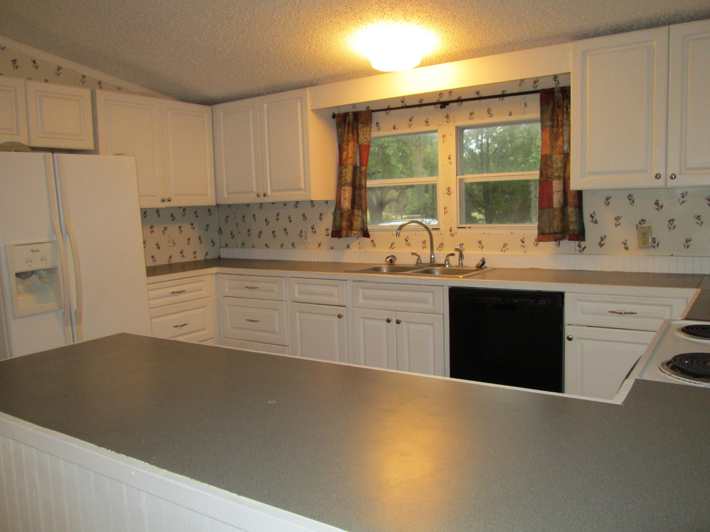 2765 Ola Broxson Road Navarre, FL 32566 - Photo 6 of 20 a kitchen with stainless steel appliances granite countertop a sink stove and refrigerator