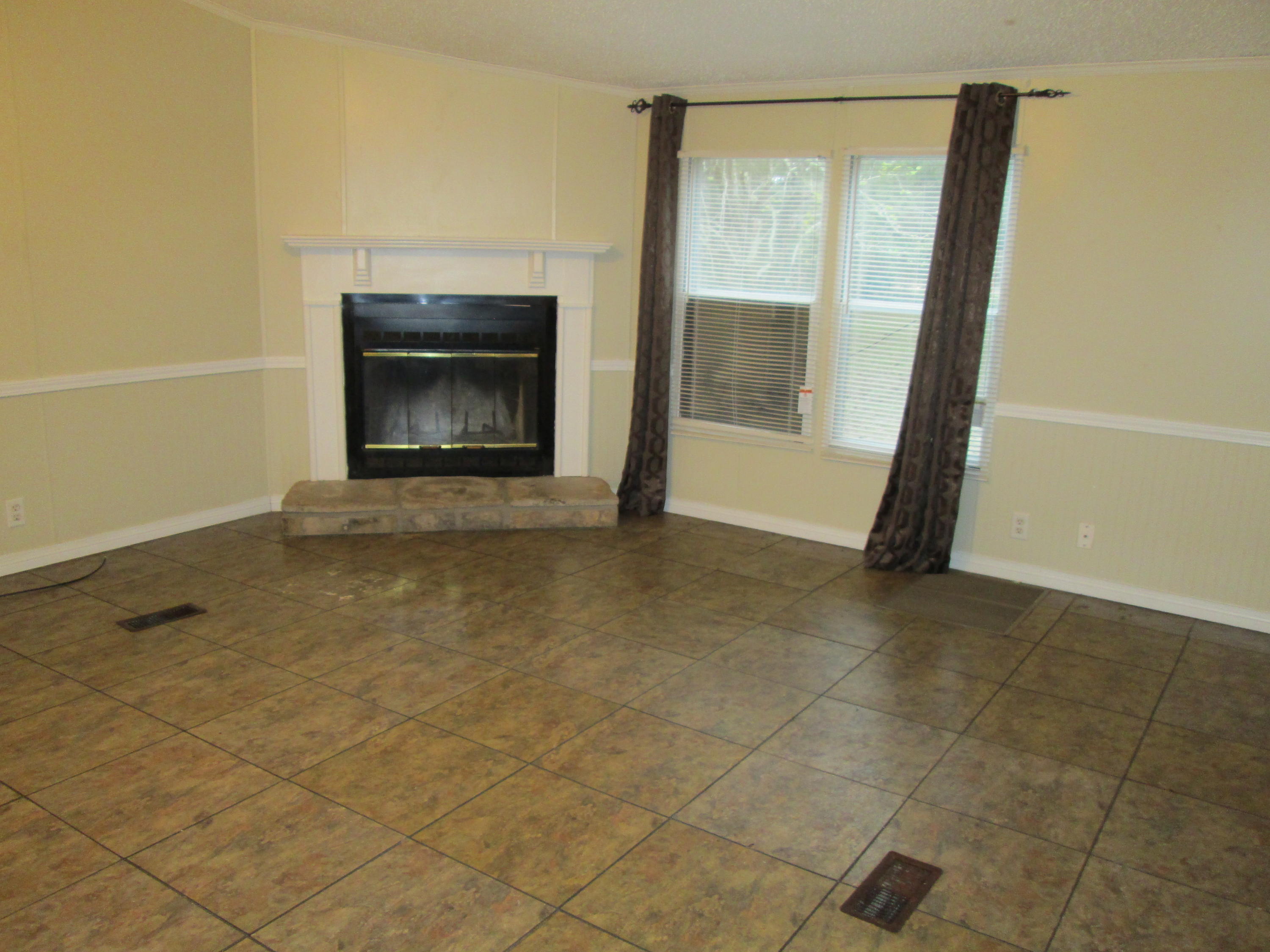 2765 Ola Broxson Road Navarre, FL 32566 - Photo 8 of 20 a view of an empty room with a fireplace and a window