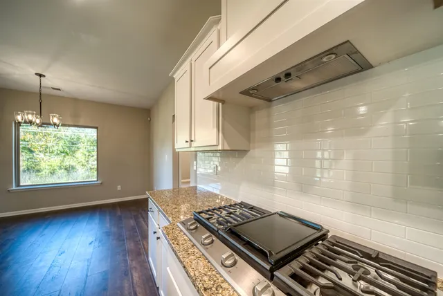 a kitchen with wooden floors and a stove