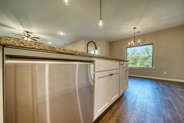 a kitchen with stainless steel appliances granite countertop a stove a sink and a refrigerator