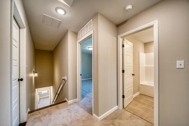 a view of a hallway with bathroom and shower