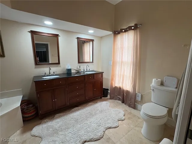 a spacious bathroom with a tub sink and mirror
