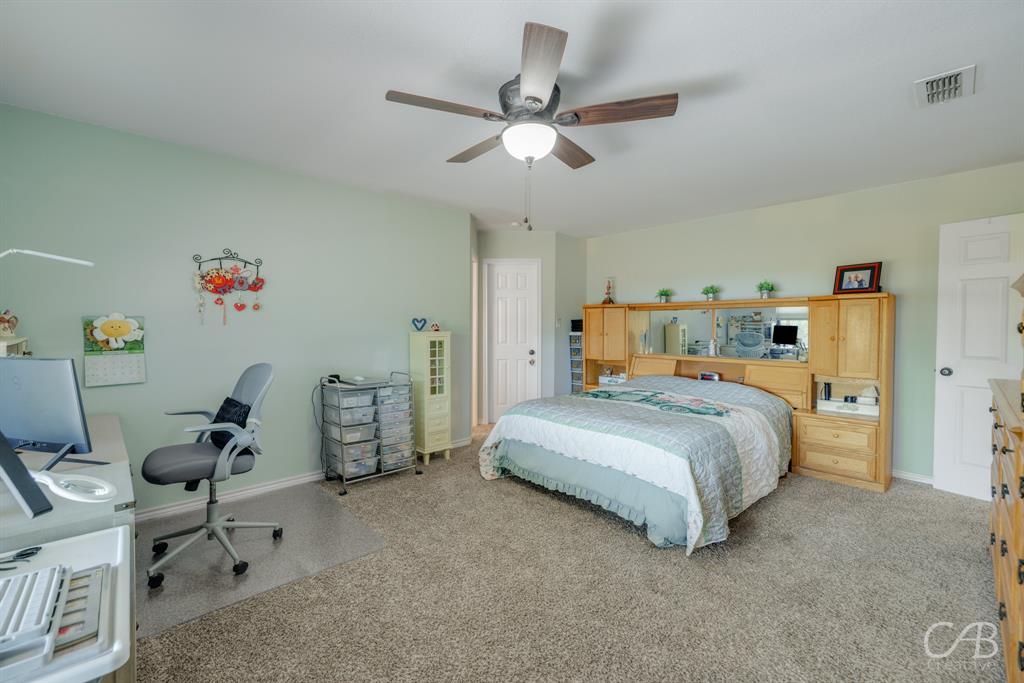 103 Arrow Point Abilene, TX 79601 - Photo 21 of 40 a bedroom with a bed and a chandelier
