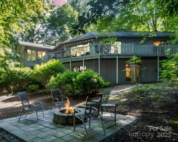 a backyard of a house with chairs and a fire pit
