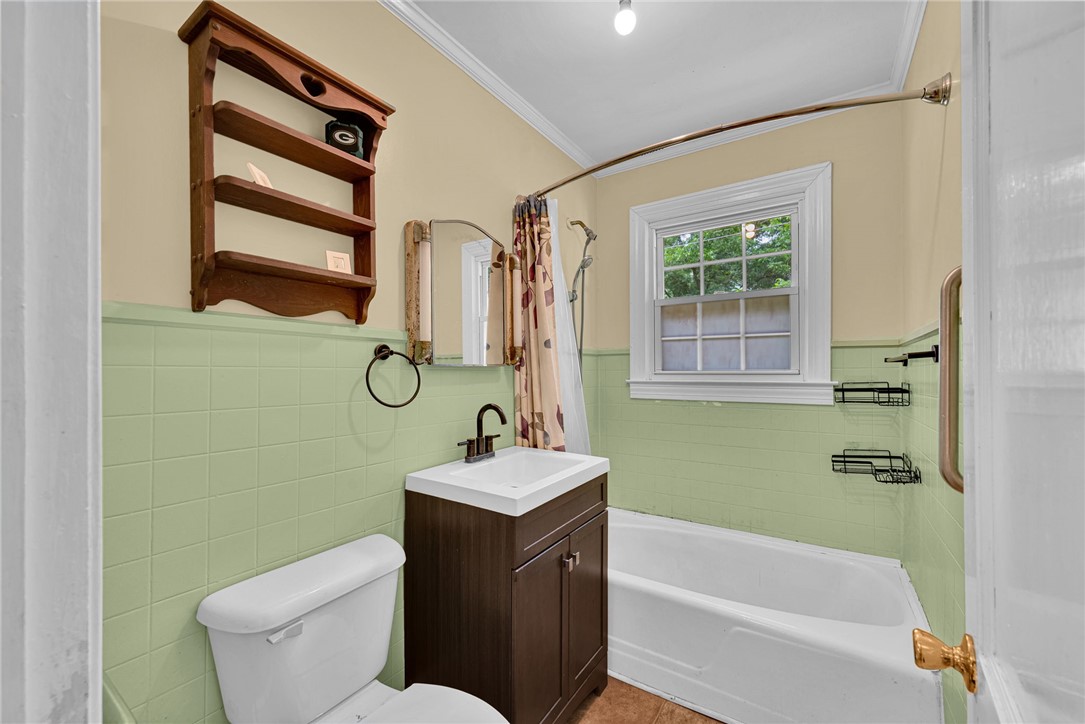 102 Graham Honea Path, SC 29654 - Photo 20 of 29 A well-lit bathroom features classic green tiled walls and a functional bathtub and vanity.