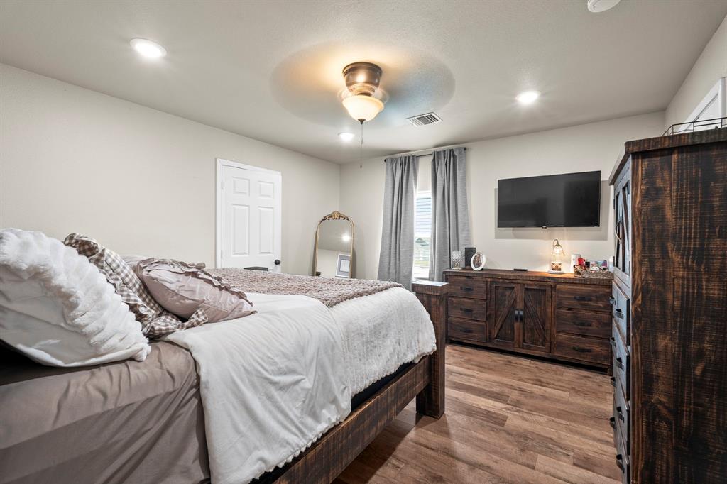 1404 McConnell Road Gunter, TX 75058 - Photo 14 of 27 a bedroom with a bed and a flat tv screen on dresser