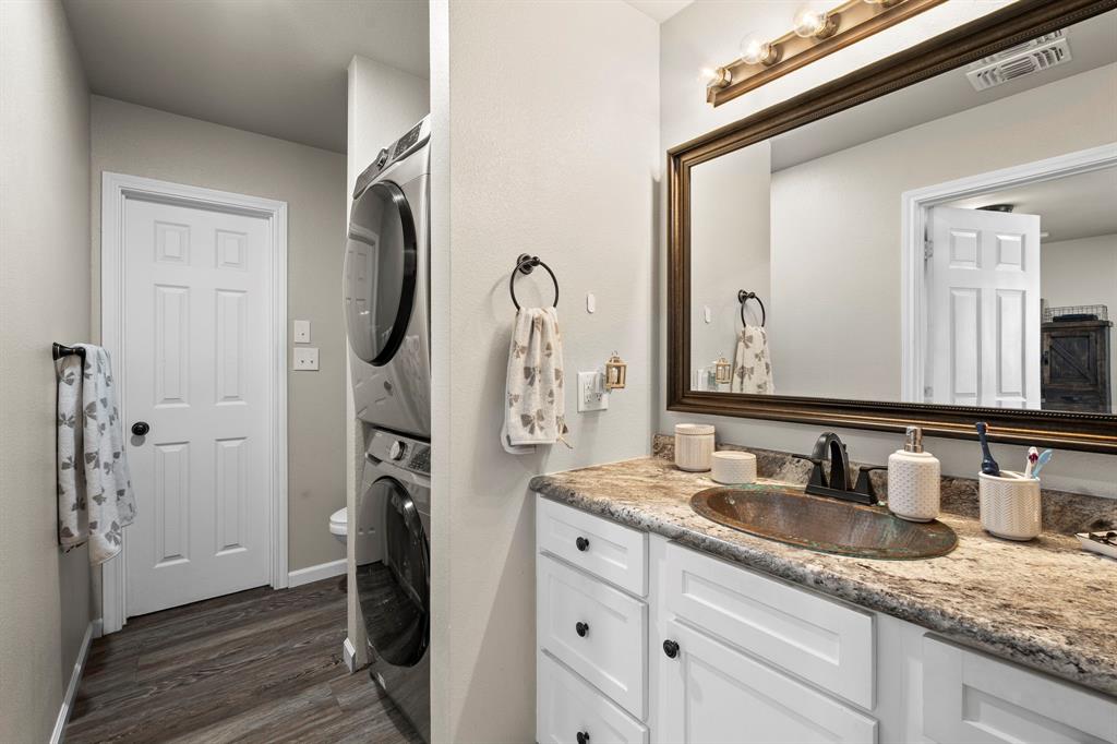 1404 McConnell Road Gunter, TX 75058 - Photo 15 of 27 a bathroom with a granite countertop sink and a mirror