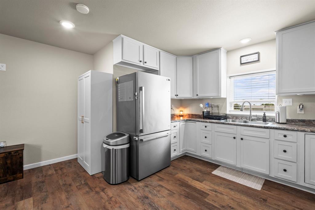 1404 McConnell Road Gunter, TX 75058 - Photo 10 of 27 a kitchen with granite countertop a refrigerator and a sink