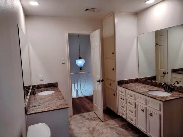 a bathroom with a granite countertop sink and a mirror