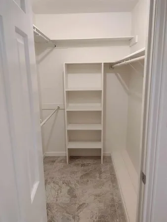 a view of walk in closet with empty racks