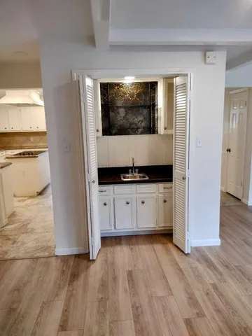 a living room with a flat screen tv and kitchen view