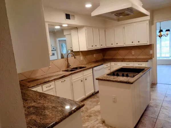 a kitchen with white cabinets and appliances