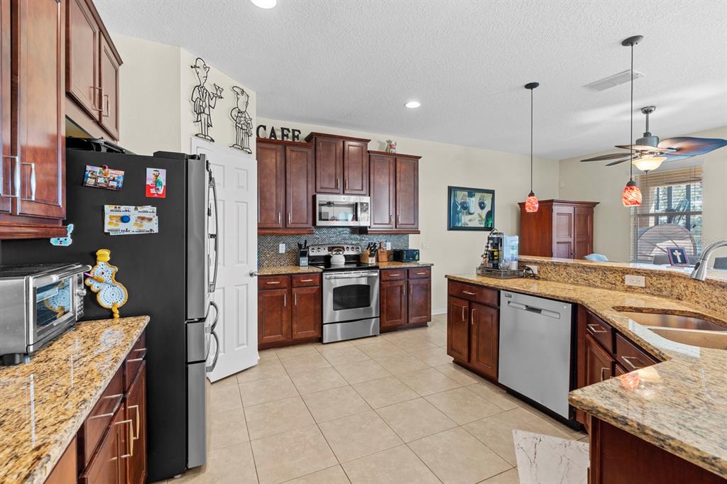 159 Star Shell Drive Apollo Beach, FL 33572 - Photo 20 of 57 a kitchen with stainless steel appliances granite countertop a stove oven and a refrigerator