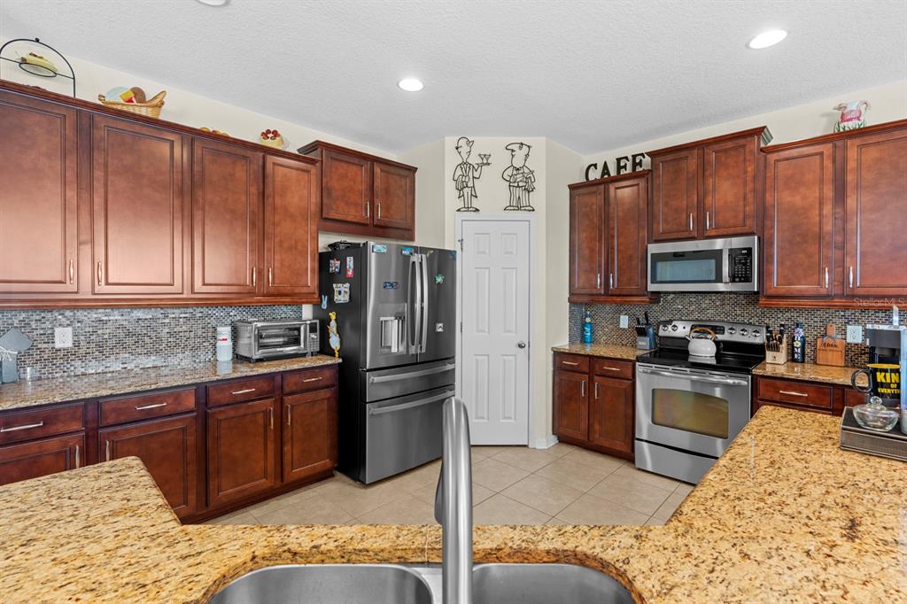 159 Star Shell Drive Apollo Beach, FL 33572 - Photo 22 of 57 a kitchen with stainless steel appliances granite countertop a refrigerator and a stove top oven