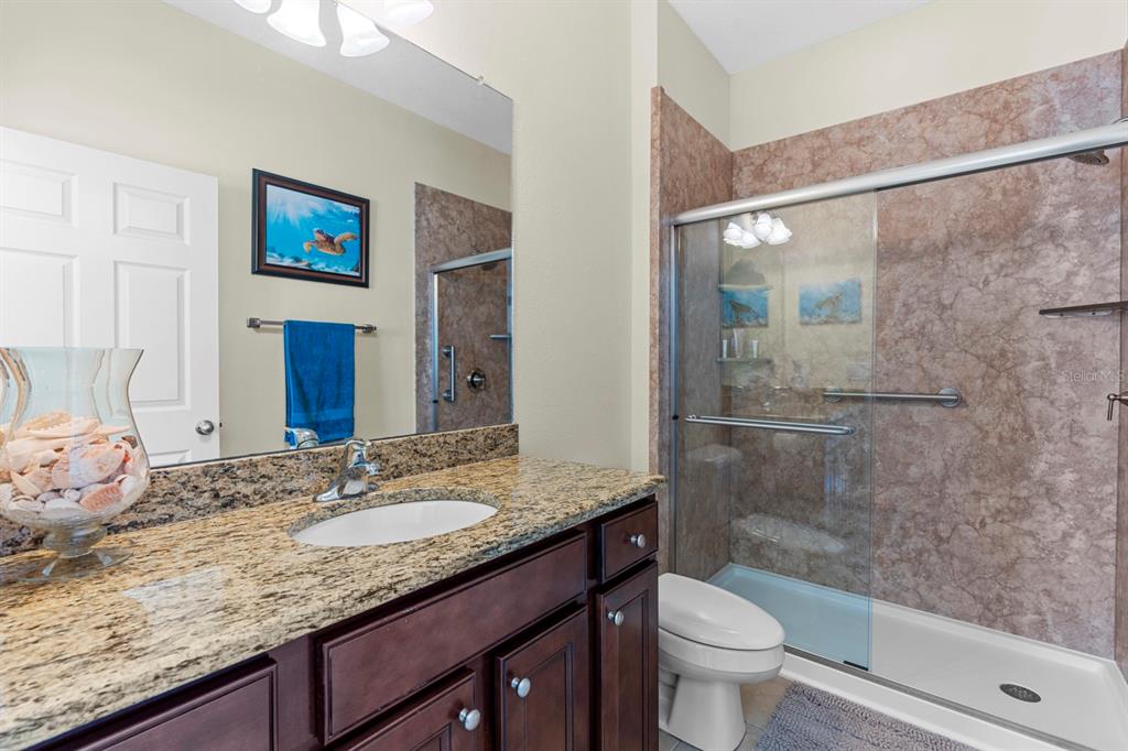 159 Star Shell Drive Apollo Beach, FL 33572 - Photo 30 of 57 a bathroom with a granite countertop sink toilet and shower