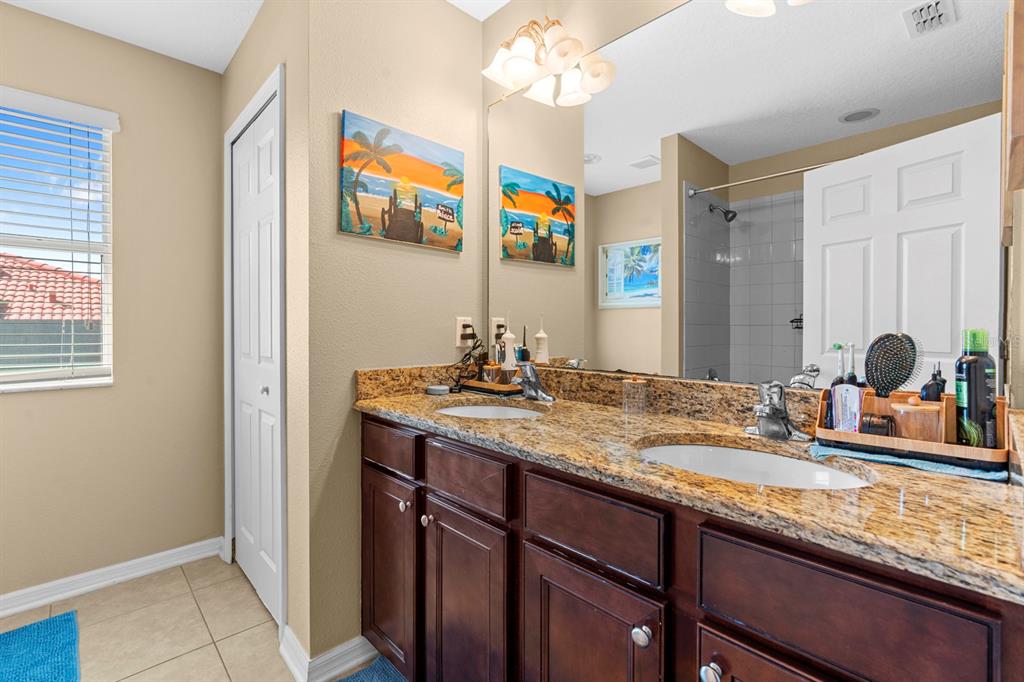 159 Star Shell Drive Apollo Beach, FL 33572 - Photo 38 of 57 a bathroom with a granite countertop sink and a mirror