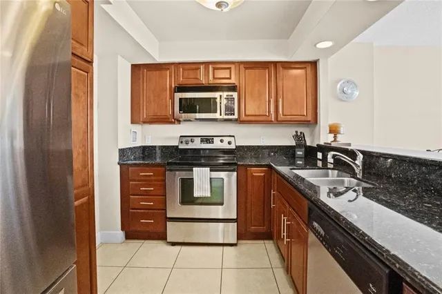 a kitchen with stainless steel appliances granite countertop a sink stove and cabinets