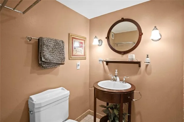 a bathroom with a toilet a sink and a mirror