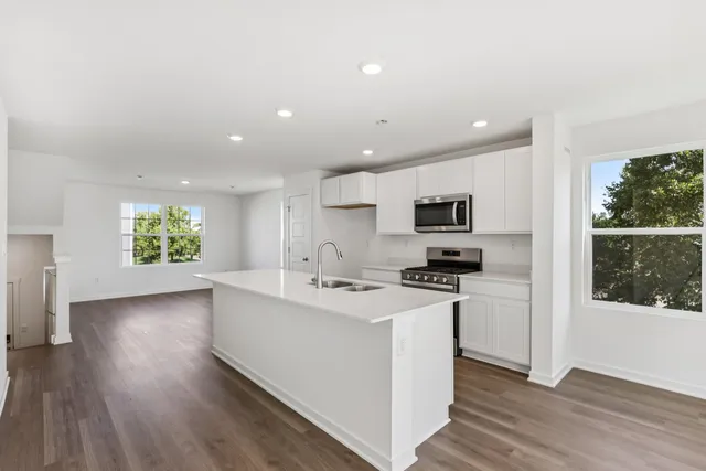 a kitchen with stainless steel appliances granite countertop a sink stove and microwave
