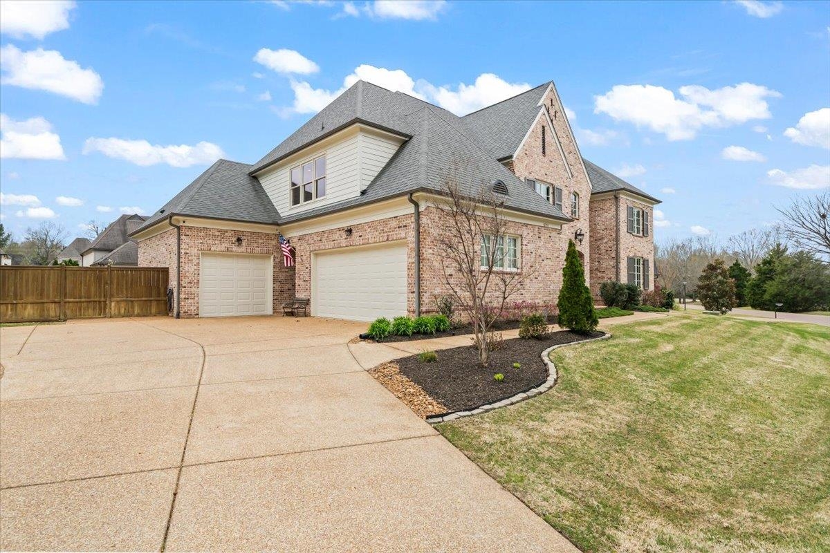 12335 Cascabel Lane Collierville, TN 38017 - Photo 2 of 38 a view of a white house with a yard and garage