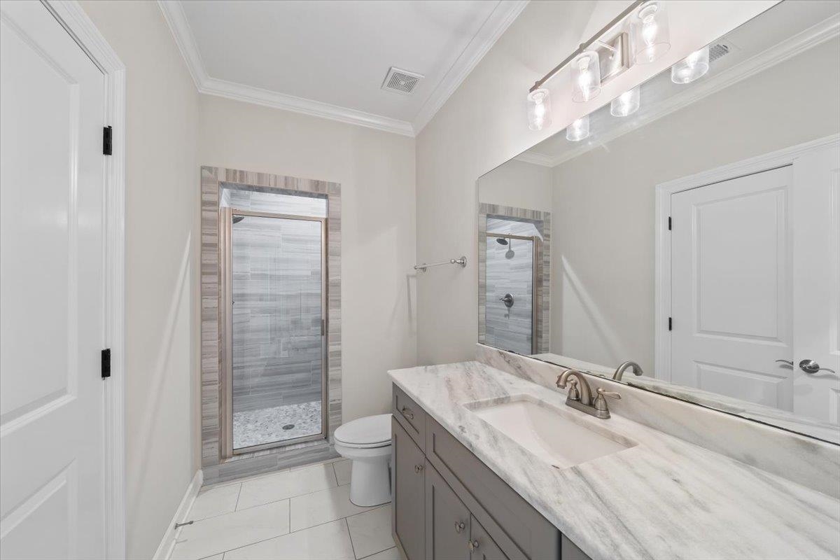 12335 Cascabel Lane Collierville, TN 38017 - Photo 26 of 38 a bathroom with a granite countertop sink a toilet a mirror and shower