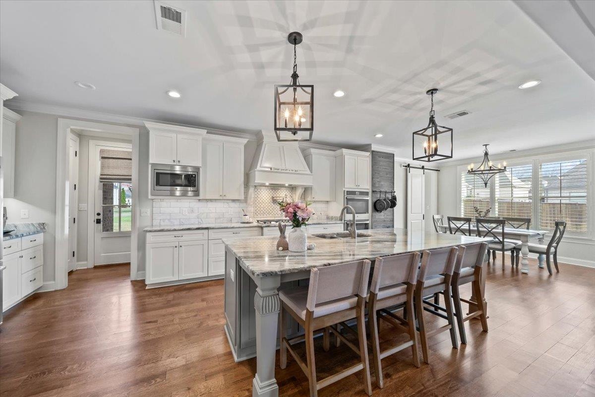 12335 Cascabel Lane Collierville, TN 38017 - Photo 10 of 38 a view of a dining room and livingroom with furniture wooden floor a chandelier
