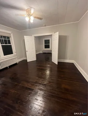a view of empty room with wooden floor
