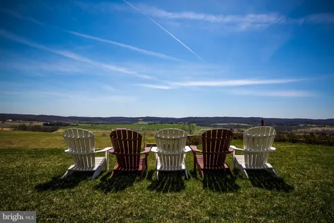 a view of house with a small deck and a wooden fence