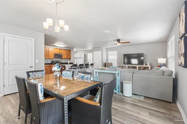 a dining room with kitchen island furniture a chandelier and kitchen view