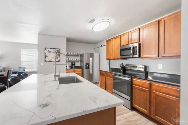 a kitchen with stainless steel appliances a stove sink microwave and cabinets