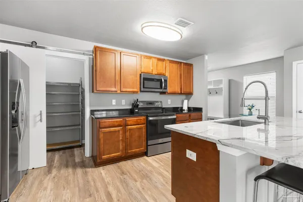 a kitchen with stainless steel appliances granite countertop a refrigerator a stove top oven a sink and dishwasher