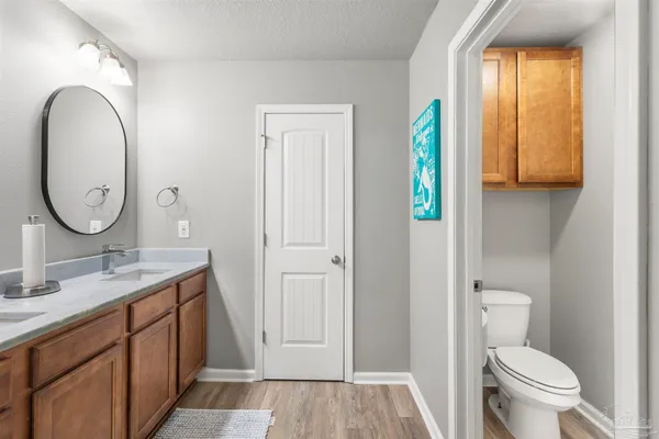 a spacious bathroom with a granite countertop toilet sink and mirror