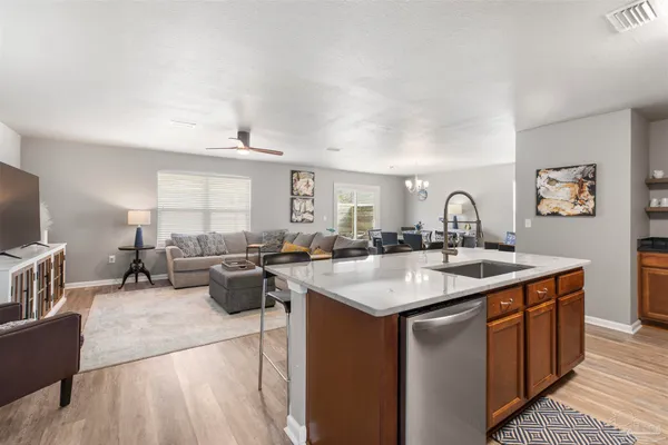 a kitchen with a sink a counter top space and living room area