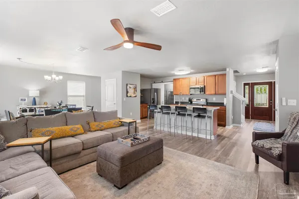 a living room with furniture kitchen view and a large window