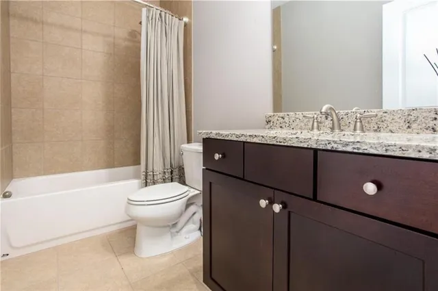 a bathroom with a granite countertop toilet a sink and a bathtub