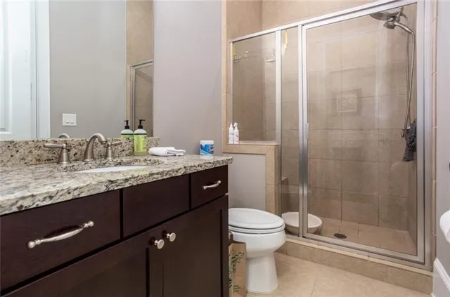 a bathroom with a granite countertop sink toilet and shower