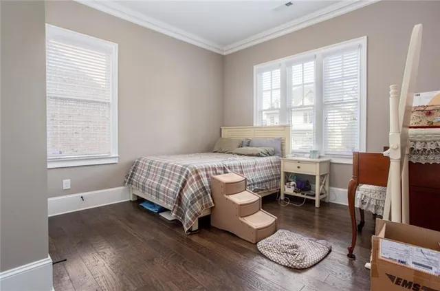 a bedroom with a bed gym equipment and a large window