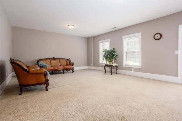 a living room with furniture a window and a potted plant