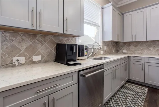 a kitchen with stainless steel appliances granite countertop a sink a stove and white cabinets