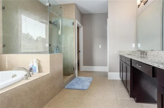 a bathroom with a tub sink and mirror