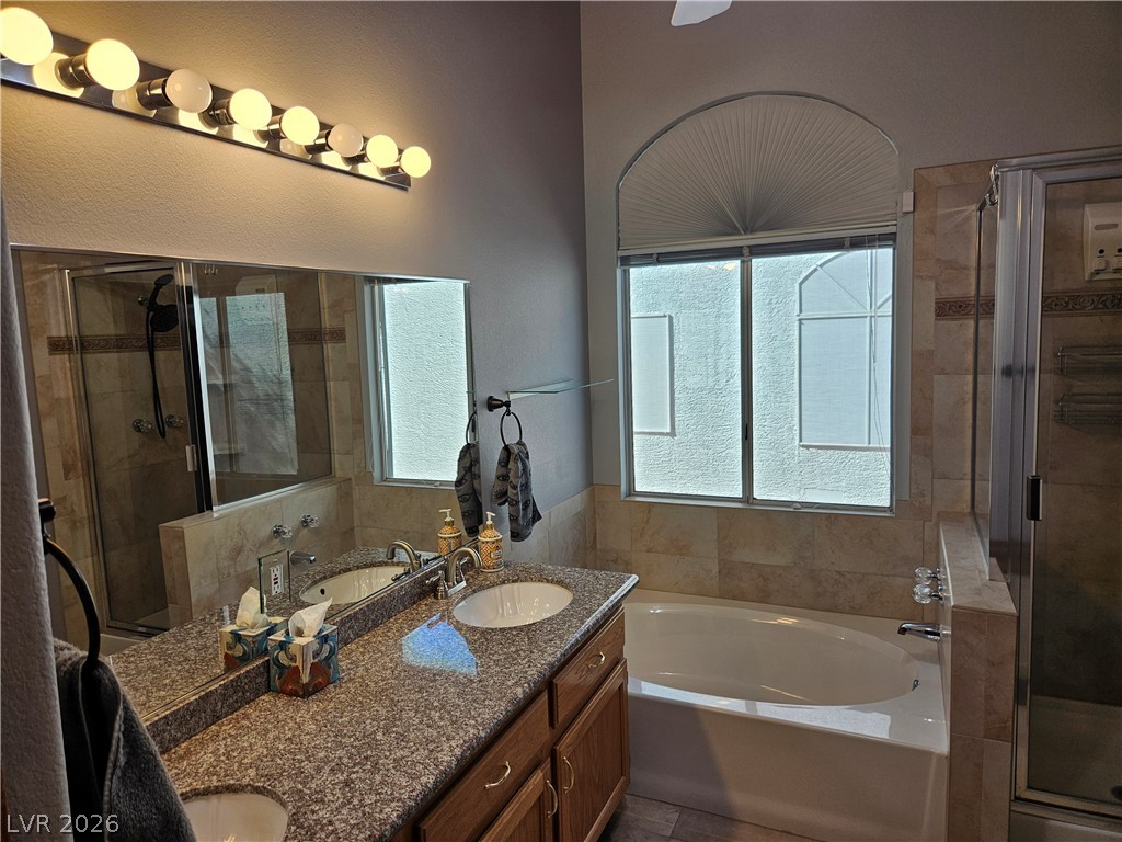 Natural light pours over the granite vanity and soaking tub in this bathroom.