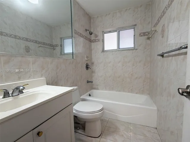 a bathroom with a toilet a sink a mirror and bathtub